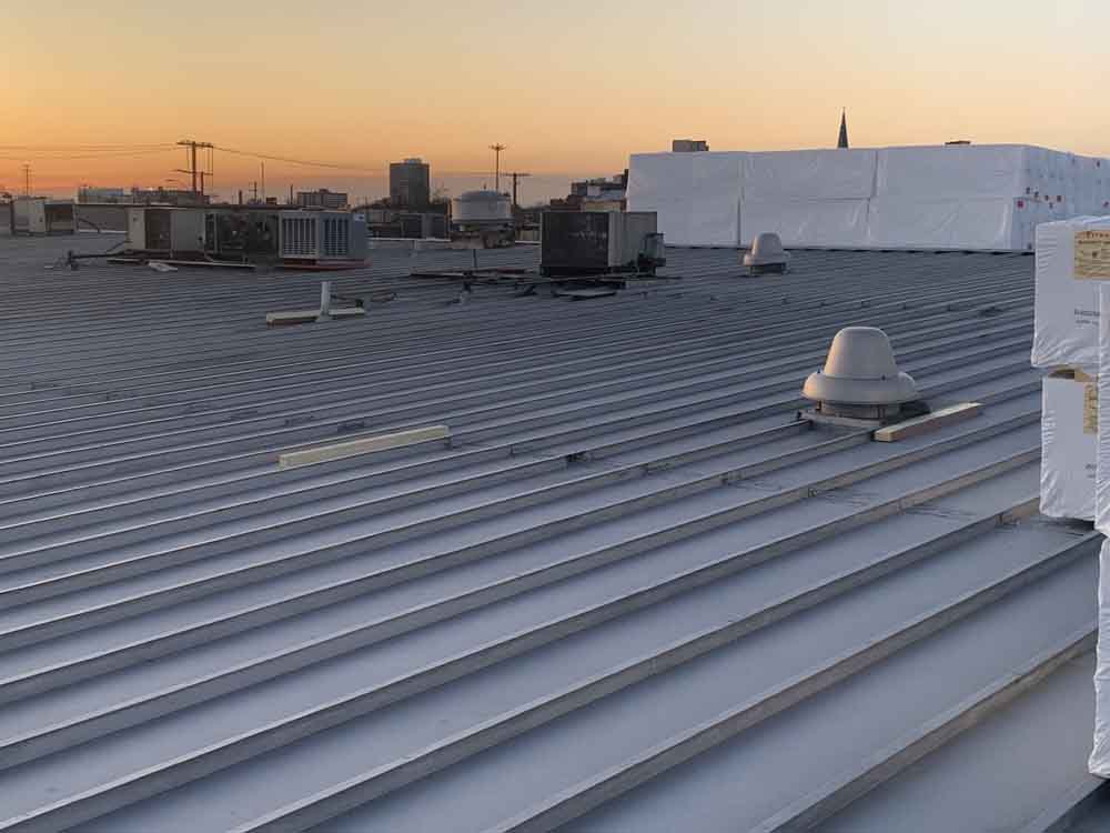 Metal roof on commercial building in Billings with the sun setting